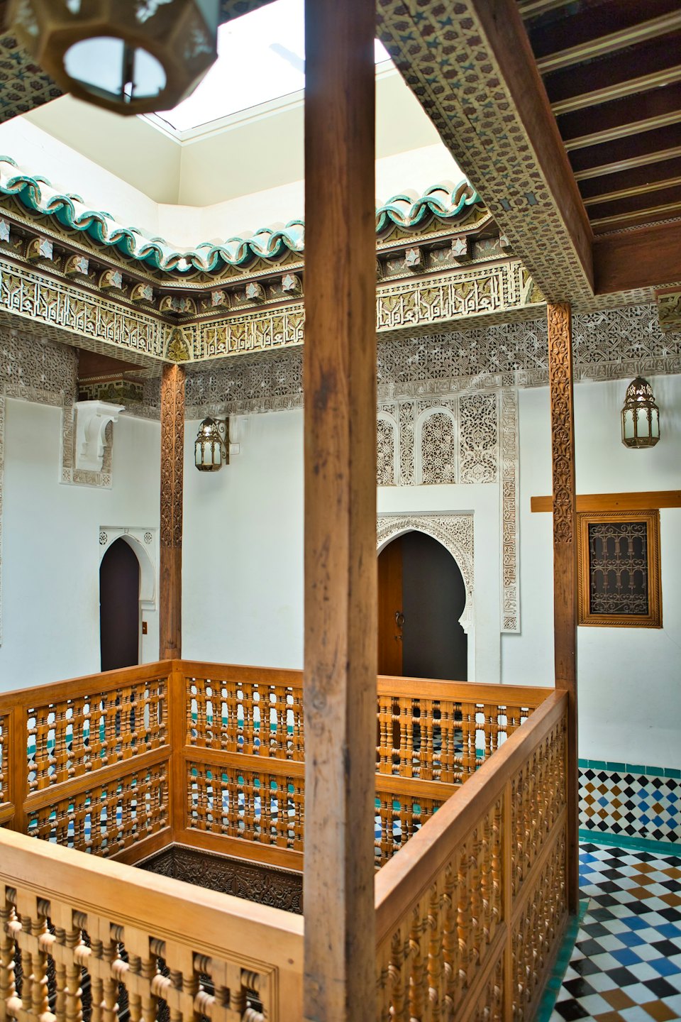 Traditional riad courtyard with ornate plasterwork and tiled floors.